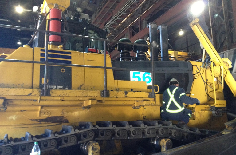 Heavy duty mechanic inspecting komatsu 475